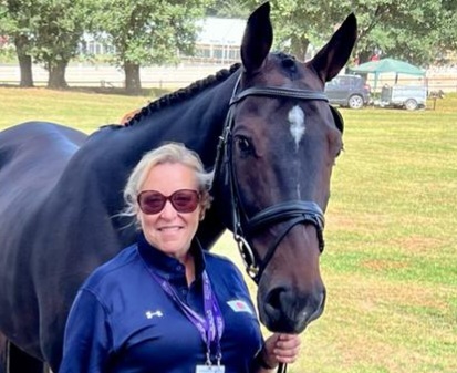 Jackie Potts holding reins of dark brown horse