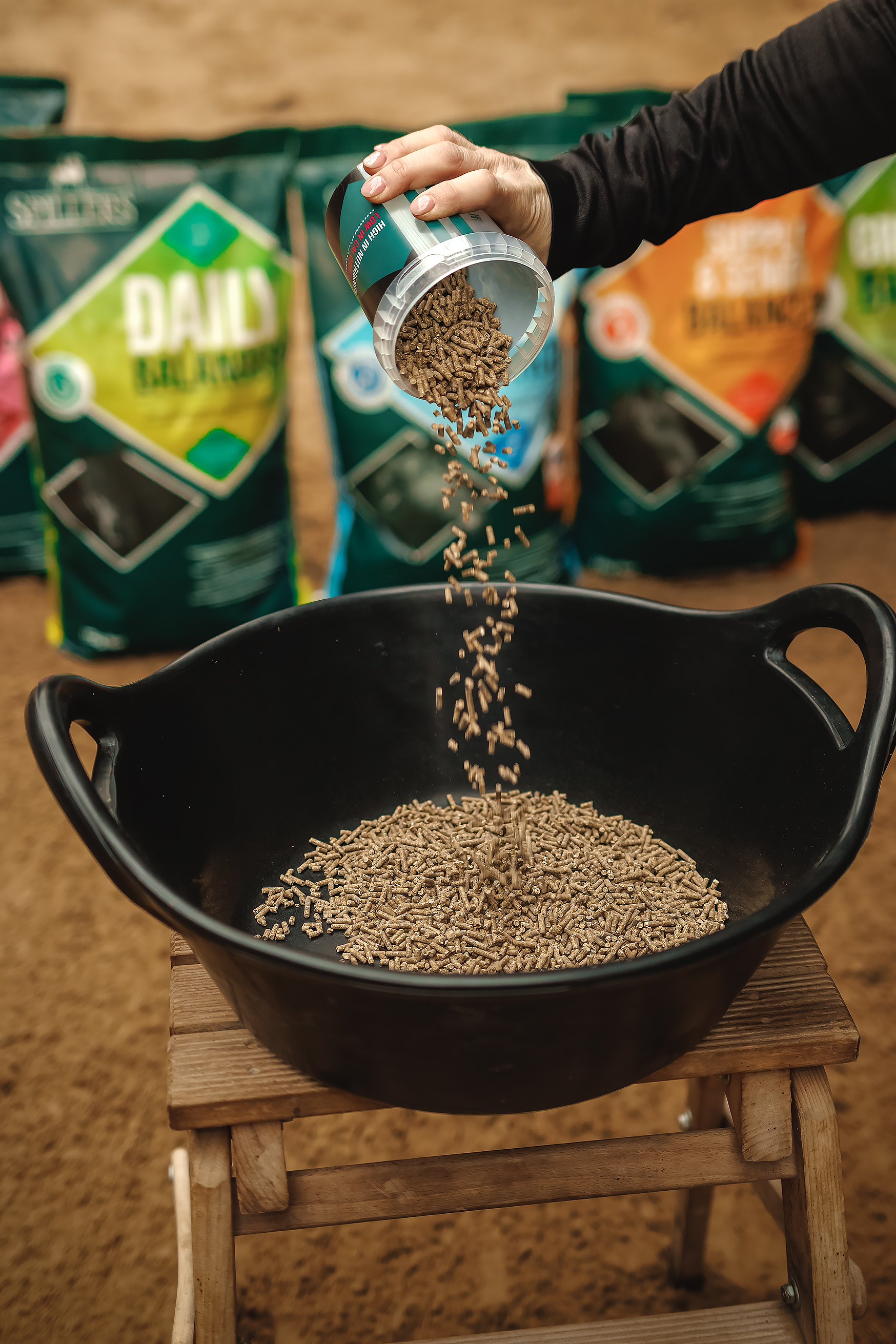 person preparing horse feed with spillers